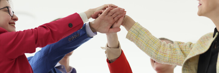 Happy businesspeople join hands during teambuilding training