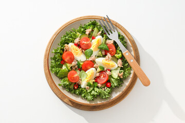 Ready salad with tuna on a wooden board.
