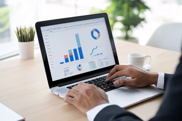 A business professional analyzes data with graphs on a laptop, showcasing statistical insights in a modern office environment.