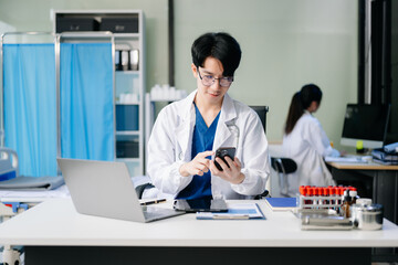 Doctor analyzing patient data on tablet in clinical lab. Medical professional in hospital with laptop, blood samples