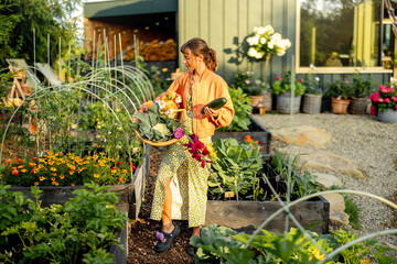 A young woman holding a basket filled with freshly harvested vegetables and vibrant flowers in a...