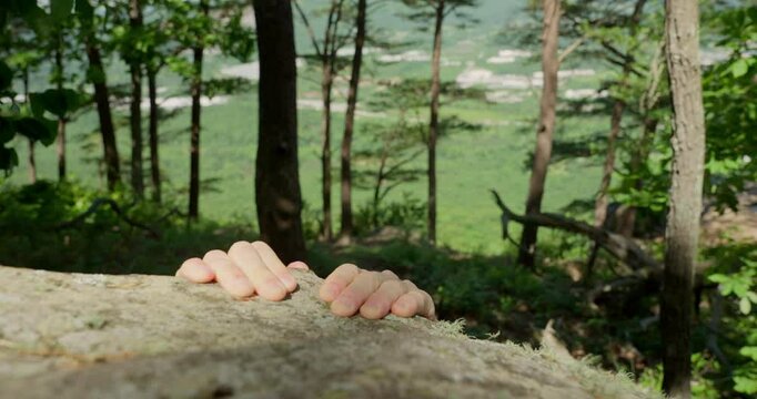 Climbing a cliff in nature. Close-up of determined hands gripping and pulling up a rugged cliff face, capturing the raw intensity and challenge of rock climbing rough surface, striving to reach top.