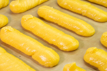 Raw eclairs on a baking sheet.Choux pastry.Dessert.Baking process.Food concept