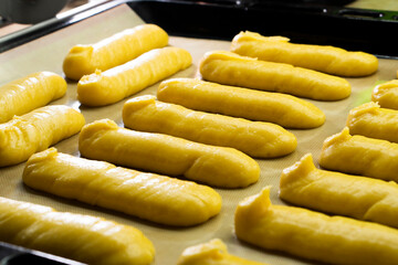 Raw eclairs on a baking sheet.Choux pastry.Dessert.Baking process.Food concept