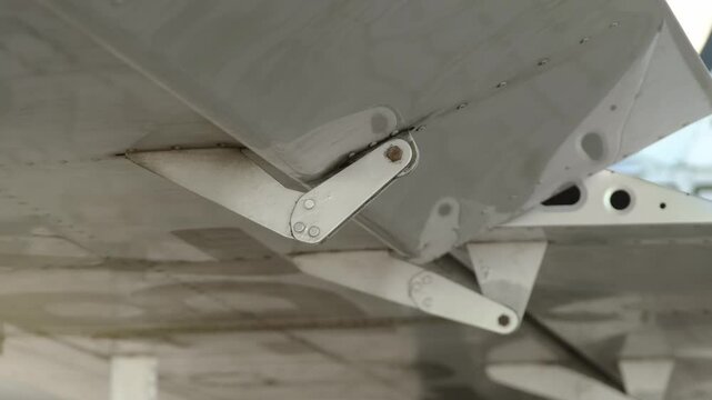 Closeup of fraise and differential type aileron on the wing of lightweight aircraft. Operation of airplanes aileron check. Checking the aircraft controls before take-off or after maintenance.