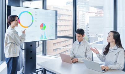 オフィスで会議をするビジネスマンたち（作業着・不動産会社）