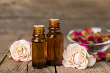 Rose essential oil on a textured background.Roses and a bottle of rose perfumed water.Aromatherapy...