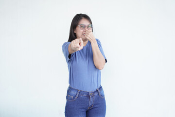 beautiful Asian woman shows a wrinkled nose in reaction to a smell while covering her nose against a white background