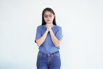 beautiful Asian woman is in a prayer gesture, with her hands clasped together against a white background