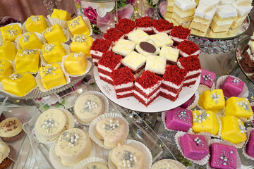 Candy bar with different assortments of cakes at a wedding