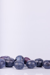 Detailed shot of blueberries on a plain white backdrop, showing their deep blue tones and fresh, organic look in a minimalist composition