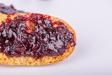 Toast with blueberry jam on a clean white background in a close-up view, highlighting the juicy texture and vivid colors of the spread