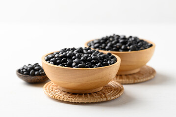 Black bean in wooden bowl with spoon on white background, Food ingredient