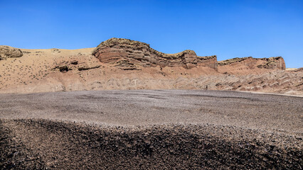 Sand road ground and Danxia landform mountain natural landscape under blue sky. Natural background.