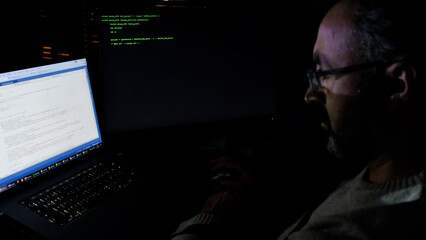 Focused Coder Analyzes Code on Computer Screen in Dark Environment - Cyber security, Cyber Attack, Penetration testing concept.