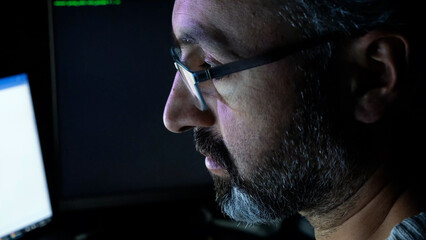 Focused Coder Analyzes Code on Computer Screen in Dark Environment - Cyber security, Cyber Attack, Penetration testing concept.