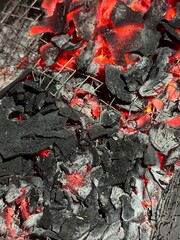 Handheld shot of charcoal in brazier, preparation for bbq