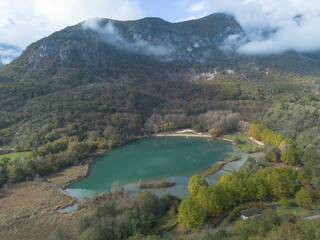 vue aérienne sur le spot de baignade aux eaux de couleurs bleus et vertes, le lac de Virieu-le-Grand dans l'Ain en France