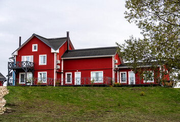 Obraz premium village with red houses and a red lighthouse on the shore of a lake on an autumn day in the Ryazan region