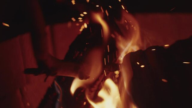 Slow motion Macro shot of wood logs burning in a campfire with sparks and smoke