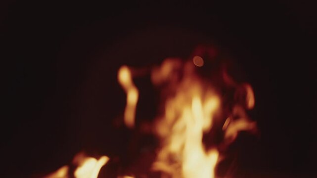 Slow motion Macro shot of wood logs burning in a campfire with sparks and smoke