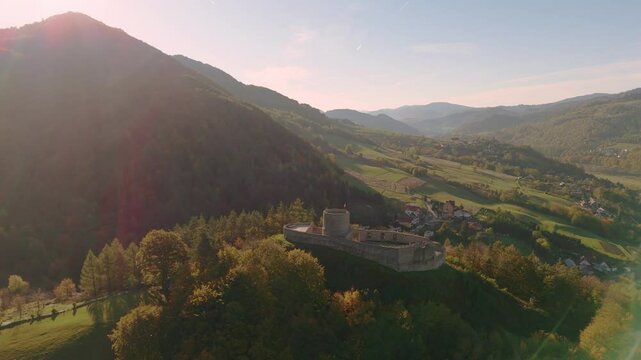 aerial flyover of rytro castle ruins in polish mountains in autumn at dawn