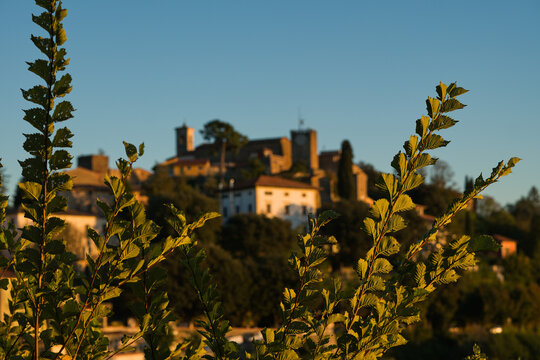 Vista di Montecatini Alto durante una serena giornata soleggiata cielo azzurro e sereno senza nuvole bianche sull'orizzonte durante un tramonto incorniciato tra due alberi.