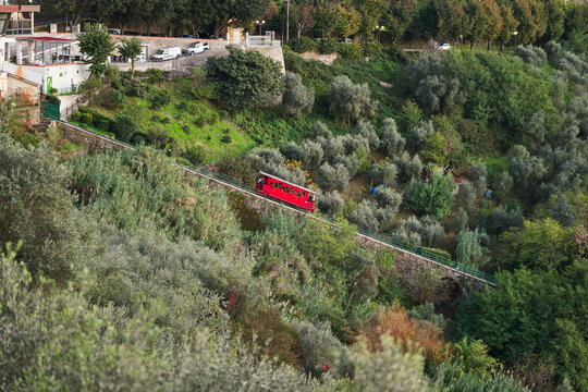 Funicolare di Montecatini Terme vista di lato con la carrozza rossa che sale verso Montecatini Alto, prossima alla stazione durante un tramonto.