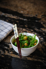 Wakame salad in a bowl and bamboo sticks
