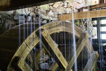 Old wooden waterwheel splashed by falling water. Picture from a watermill in Sweden