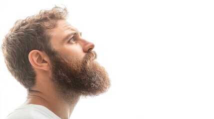 Fototapeta premium Profile of a bearded man looking away, isolated against a white background. This image captures a side view of a man with a beard, providing ample copy space for text or use.