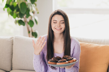 Photo of lovely young teen girl smell baked bun taste dressed violet garment spacious house bright...