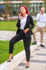 Businesswoman having phone call in front of businessman