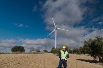 Wind turbine engineer inspecting a wind farm for renewable energy production