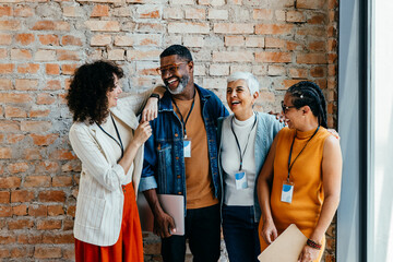 Coworkers laughing and sharing joyful moments in a modern office setting during a casual break