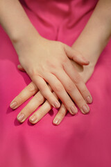 Hands of a woman on a pink background