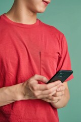 A young boy holding a cell phone, possibly texting or gaming