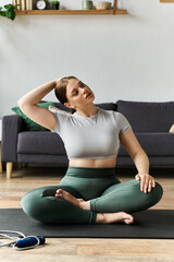 Fototapeta premium A young sportive woman practices yoga at home, focusing on her flexibility and mindfulness during exercise.