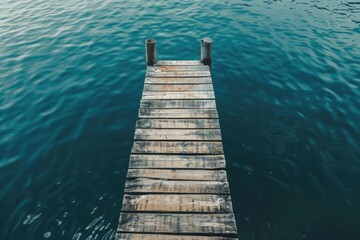 Fototapeta premium A simple wooden dock extends into the calm waters of a lake or sea