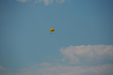 A yellow air balloon flies far in the sky.