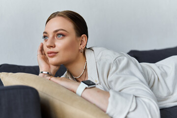 Young woman in casual wear and smart watch relaxing on couch