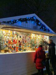 Holiday Spirit in the Air at the Christmas Market Stall. Holiday Shopping Under Twinkling Lights.