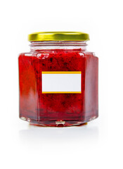Hexagonal glass jar of homemade red currant berry or cranberry jam with a gold lid and blank label....