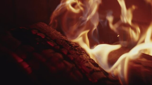 Slow motion Macro shot of wood logs burning in a campfire with sparks and smoke