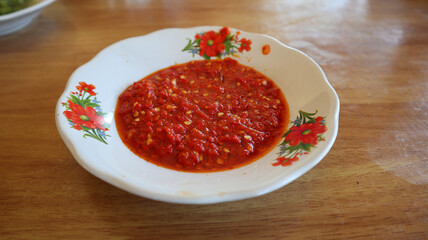Sambal cabe merah or red chili sambal in Padang restaurant. served on red plate