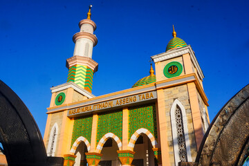 The splendor of the mosque and its towering minaret under the blue sky creates a stunning view
