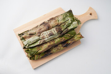 Otak-otak is a dish made from minced mackerel wrapped in banana leaves, grilled, and served with...