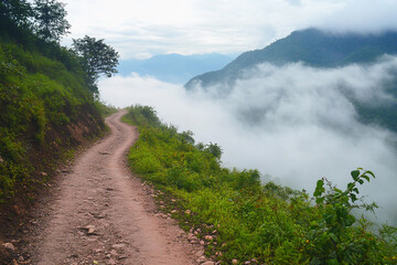 Serene mountain pathway winding through misty hills at dawn