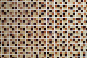 colorful small square of ceramic tile on the wall. brown and white mosaic pattern