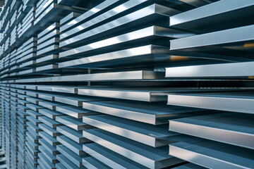 Fototapeta premium Industrial Aluminum Sheet Metal Storage in Modern Warehouse. Stacks of raw aluminum sheets and plates organized in a modern manufacturing warehouse facility.